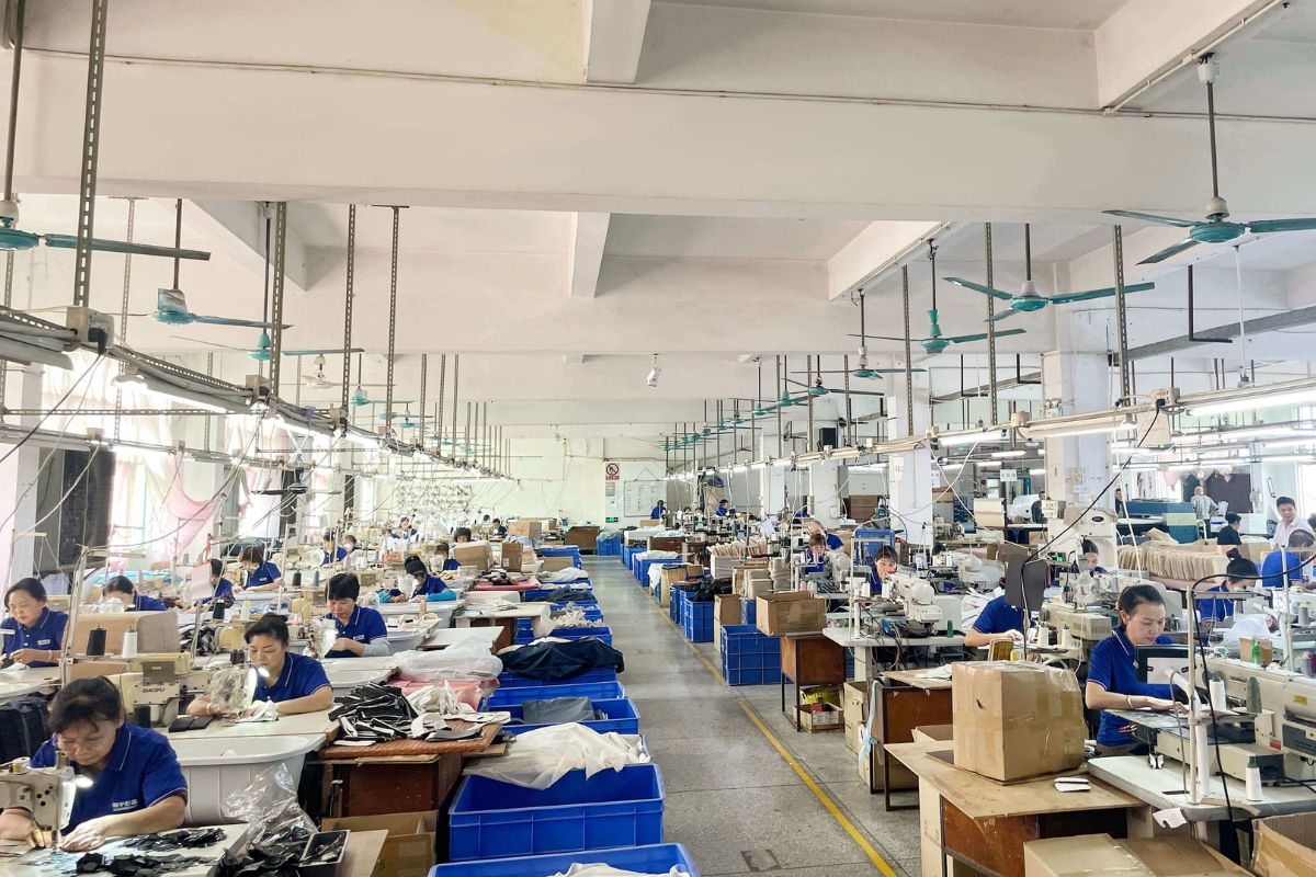 a factory worker inspecting a nylon bag on a production line
